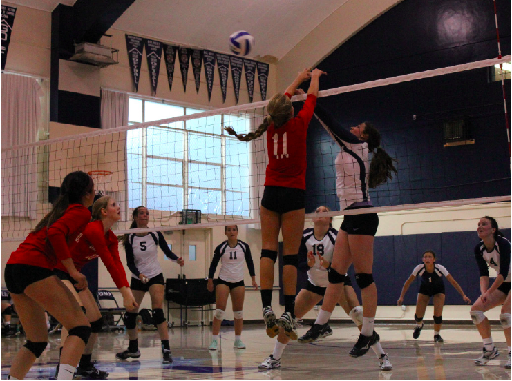 Tip! Devan Gallager (15) scores a point in a loss to University on Sept. 28. Historically,
volleyball matches with Urban have been dominated by the Red Devils.