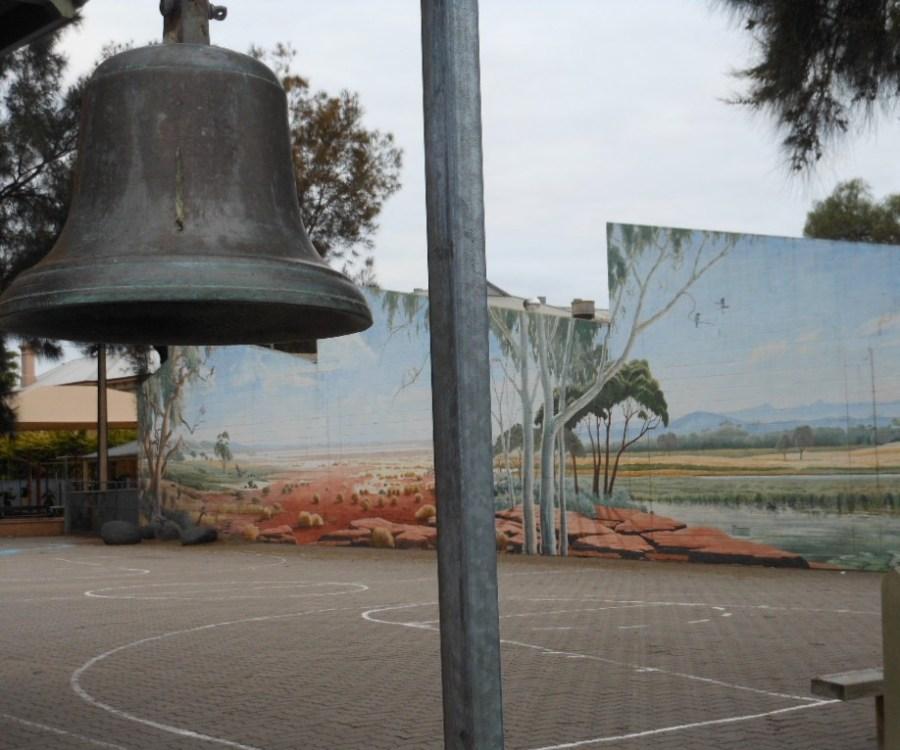 An old school bell sits in the courtyard of a school
photo by Michael Coghlan